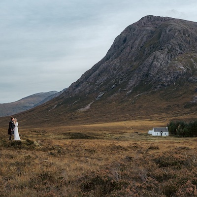 A bride and groom next to a mountain in Glencoe